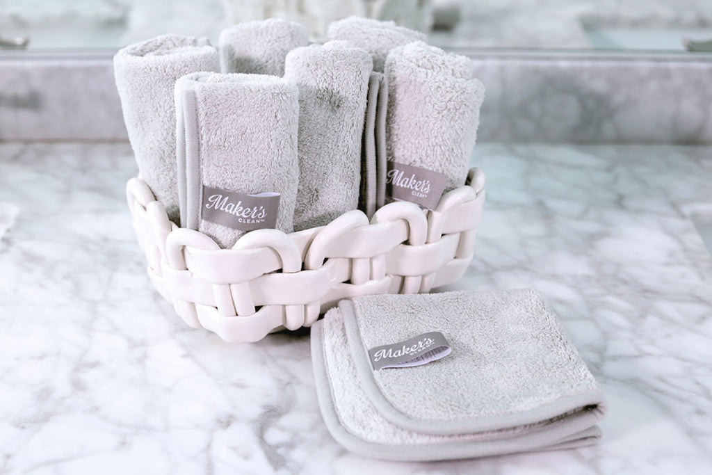 grey face cloths rolled up in a white basket
