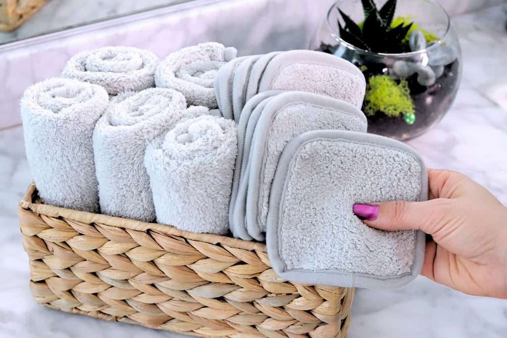 grey face cloths and makeup pads in a wooden basket